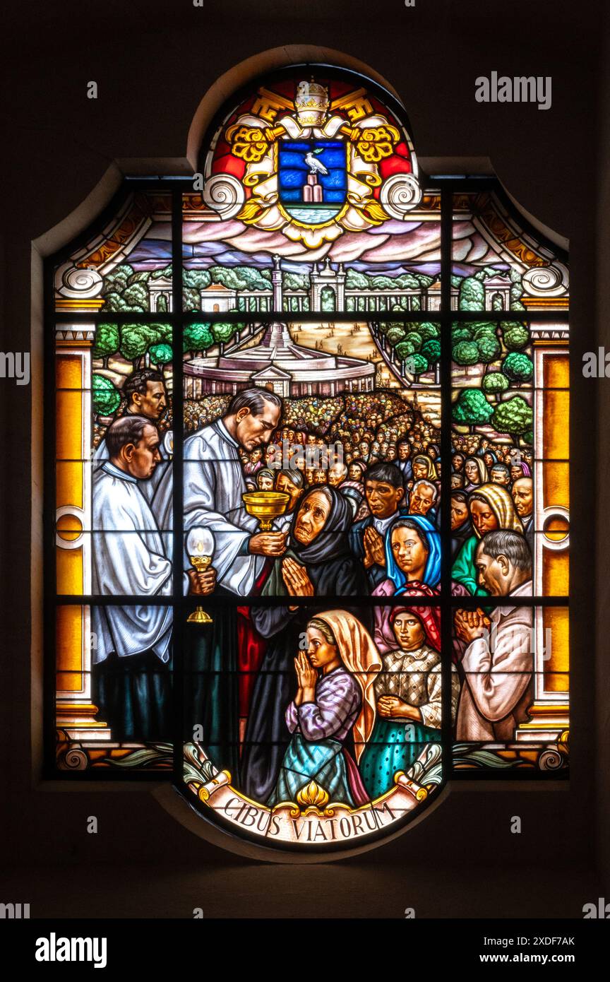 Un prêtre distribuant la communion aux fidèles. Un vitrail dans la basilique notre-Dame du Rosaire à Fatima, Portugal. Banque D'Images