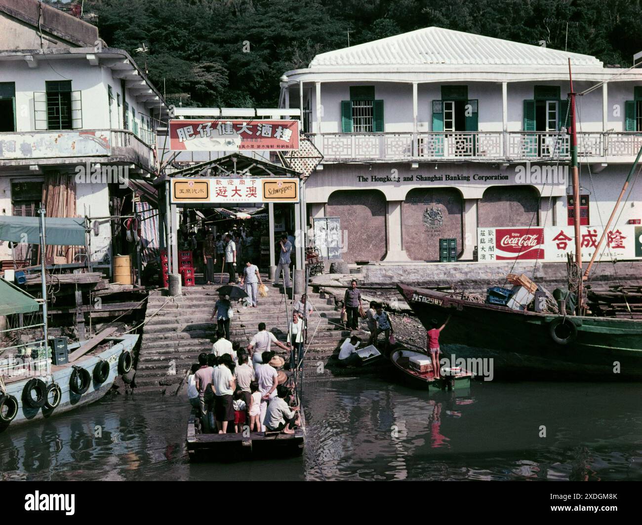 Villageois utilisant le ponton Ferry à Tai O Village, Lantau, Hong Kong - Hong Kong et Shanghai Bank à droite. 1984. Le ferry a été remplacé par un pont depuis les années 1990 Banque D'Images