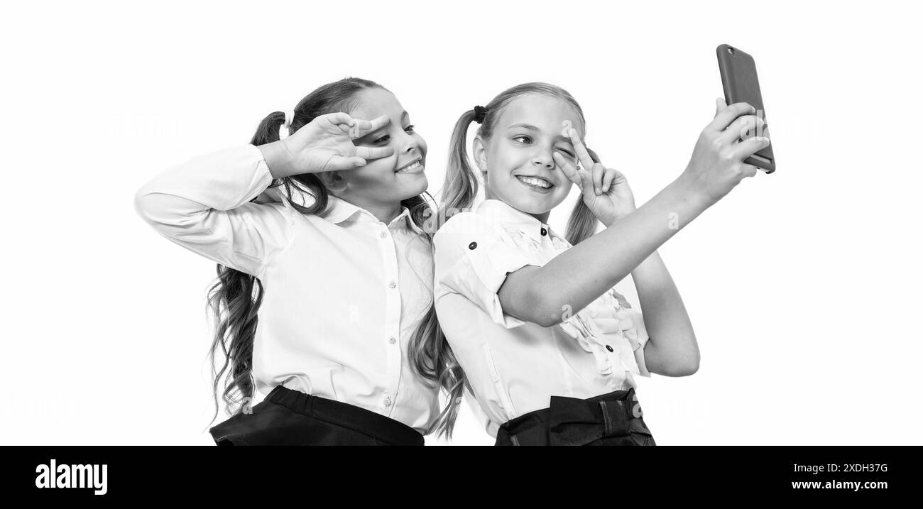 filles enfants ayant le temps de selfie. amis de l'école blogeant et prenant selfie avec le téléphone. écoliers faisant selfie en classe. retour à l'école Banque D'Images