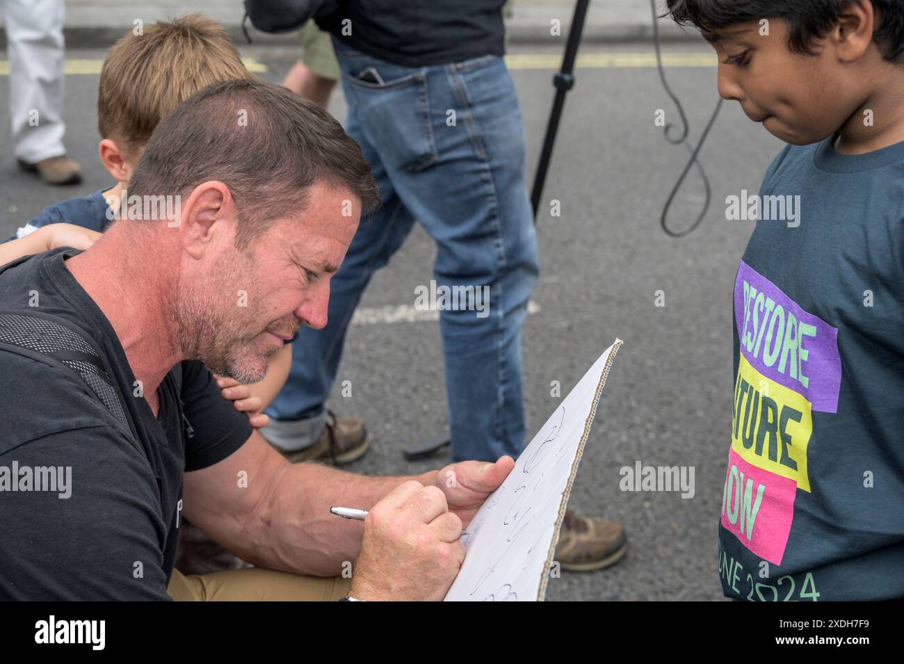 Steve Backshall - présentateur nature TV - signature d'un autographe pour Aneeshwar Kunchala - naturaliste / conservationniste - à la Restore nature Now march Banque D'Images