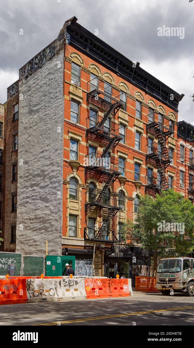 NYC Chinatown : 13 Essex Street, un immeuble d'appartements en brique de six étages, a des magasins au rez-de-chaussée, des garnitures en pierre moulée et une corniche en métal estampé. Banque D'Images