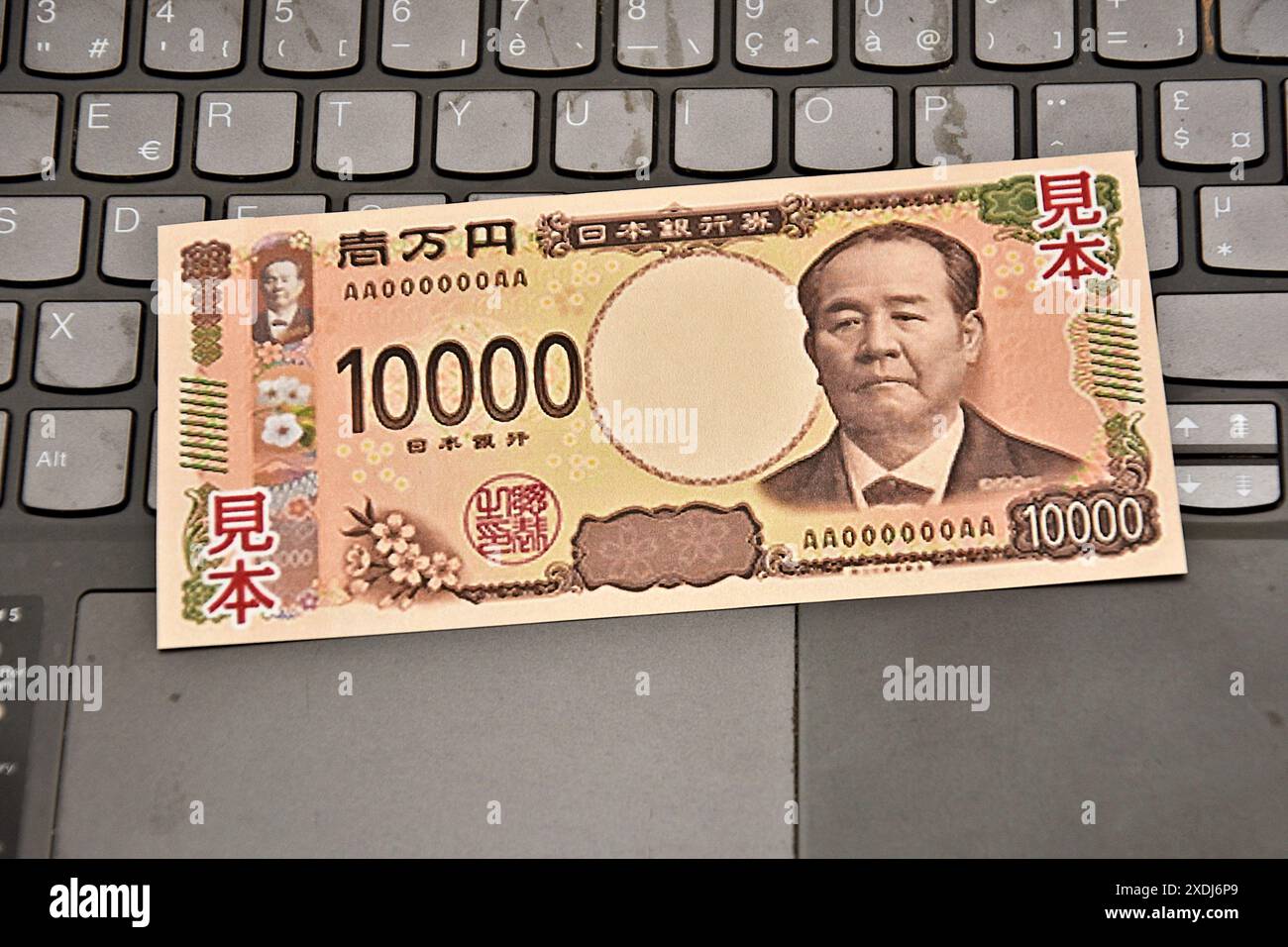 Dans cette illustration photo, un échantillon d'un billet de banque japonais de 10 000 yens est placé sur le clavier d'un ordinateur portable. Pour réduire le risque de contrefaçon, le ministère des Finances et la Banque du Japon mettront en circulation de nouveaux billets de 1 000, 5 000 et 10 000 yens au début du mois de juillet 2024. Banque D'Images