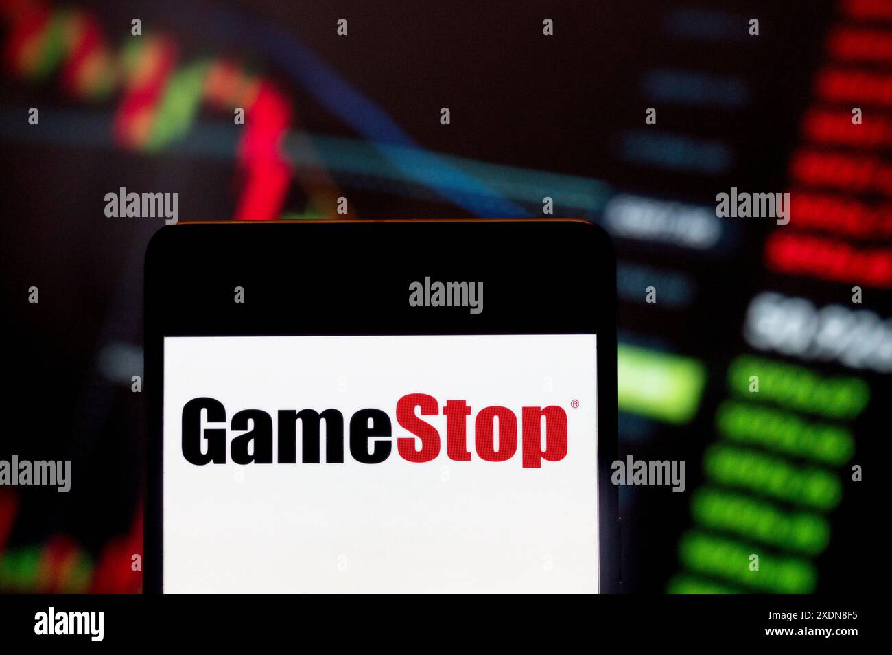 Chine. 23 juin 2024. Dans cette illustration photo, le détaillant américain de jeux vidéo, d'électronique grand public et de marchandises de jeu, GameStop Corp (NYSE : GME), logo vu affiché sur un smartphone avec un graphique d'indice boursier économique en arrière-plan. (Crédit image : © Budrul Chukrut/SOPA images via ZUMA Press Wire) USAGE ÉDITORIAL SEULEMENT! Non destiné à UN USAGE commercial ! Banque D'Images