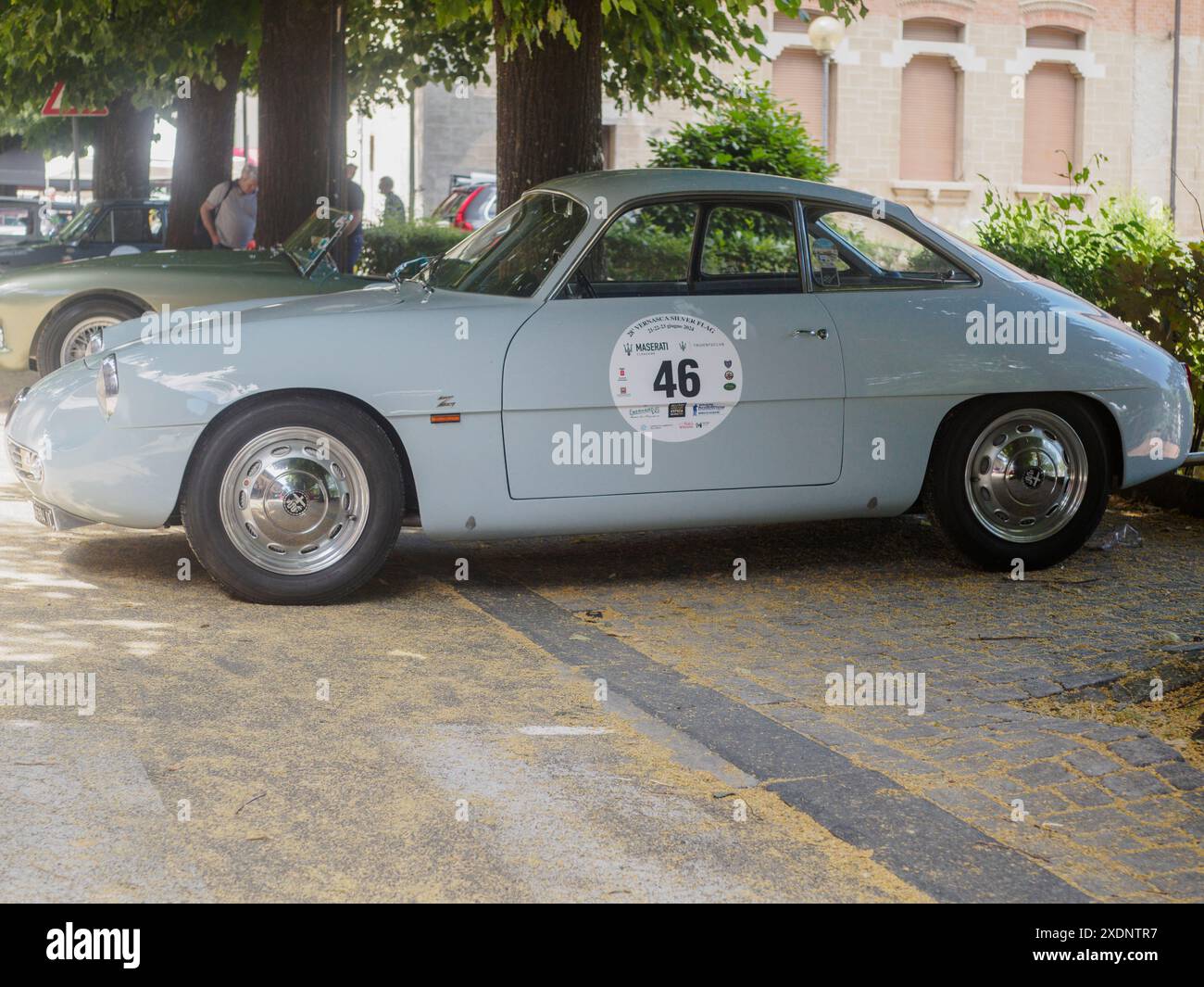 Castellarquato, Italie - 22 juin 2024 Rallye drapeau d'argent , Classic bleu clair alfa romeo giulietta sprint speciale stationné sur une route de briques sous les arbres Banque D'Images