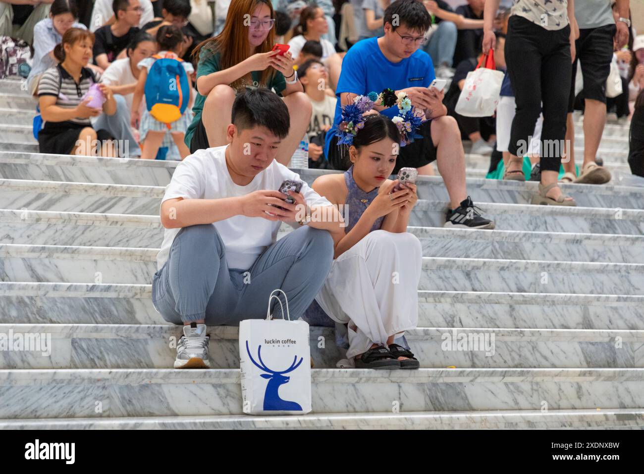 JINAN, CHINE - 23 JUIN 2024 - les gens sont assis sur les marches de la salle du musée du Shandong pour se rafraîchir dans la province du Shandong, province du Shandong en Chine orientale Banque D'Images