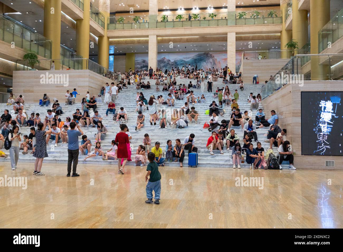 JINAN, CHINE - 23 JUIN 2024 - les gens sont assis sur les marches de la salle du musée du Shandong pour se rafraîchir dans la province du Shandong, province du Shandong en Chine orientale Banque D'Images