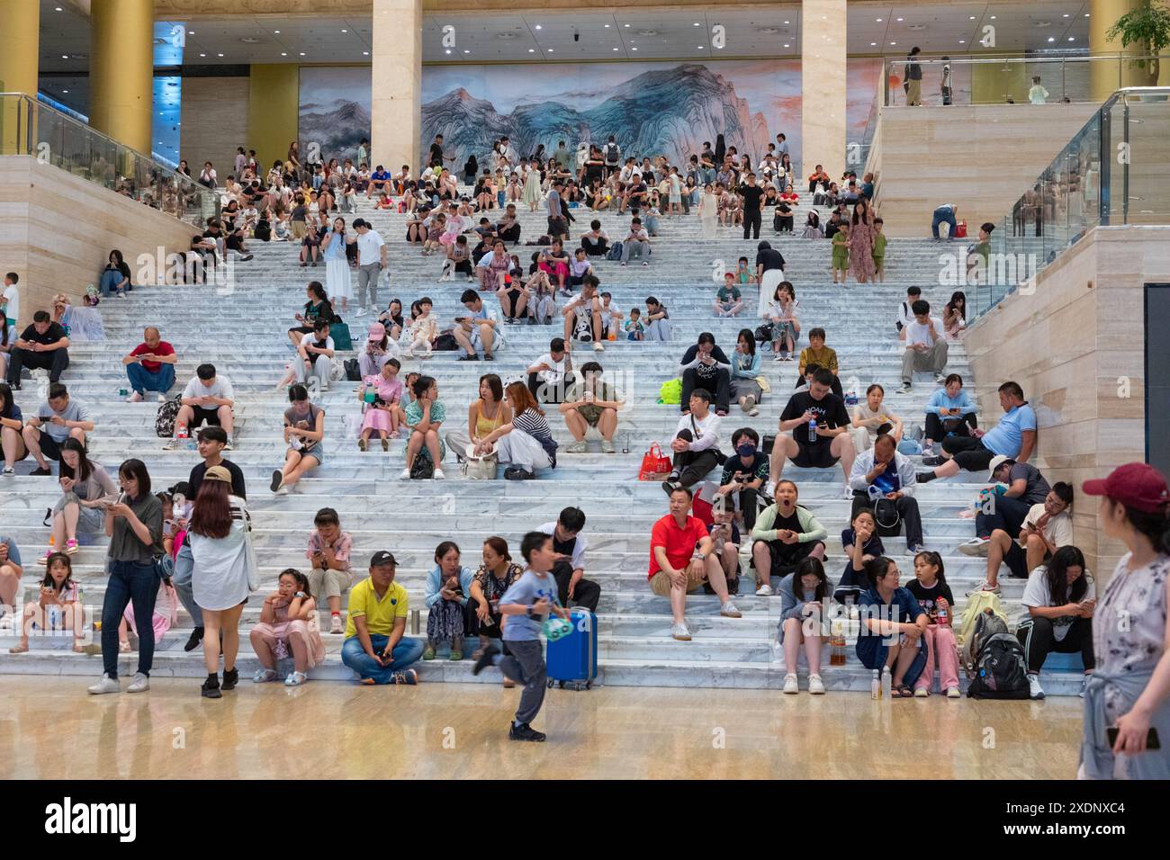 JINAN, CHINE - 23 JUIN 2024 - les gens sont assis sur les marches de la salle du musée du Shandong pour se rafraîchir dans la province du Shandong, province du Shandong en Chine orientale Banque D'Images