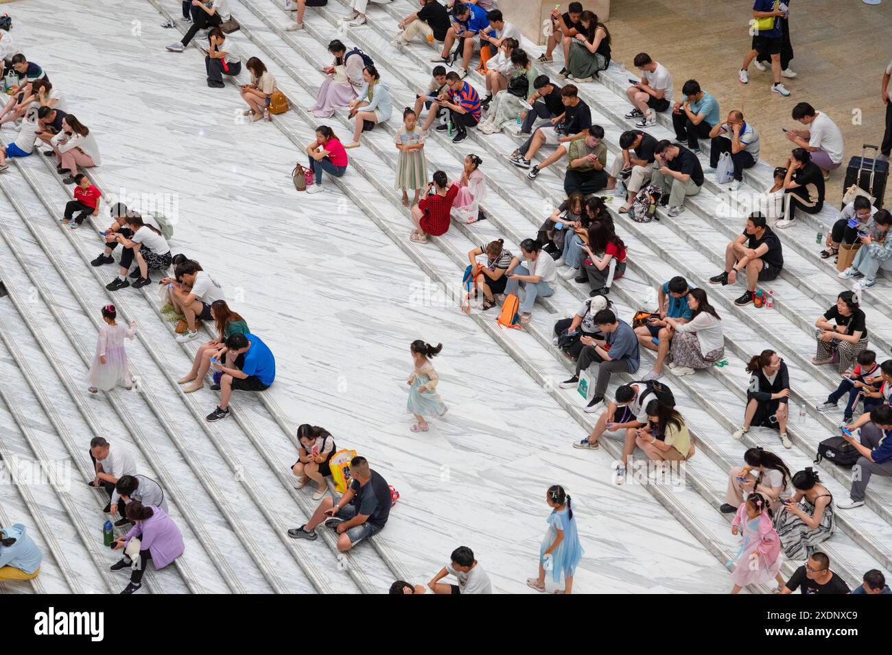 JINAN, CHINE - 23 JUIN 2024 - les gens sont assis sur les marches de la salle du musée du Shandong pour se rafraîchir dans la province du Shandong, province du Shandong en Chine orientale Banque D'Images