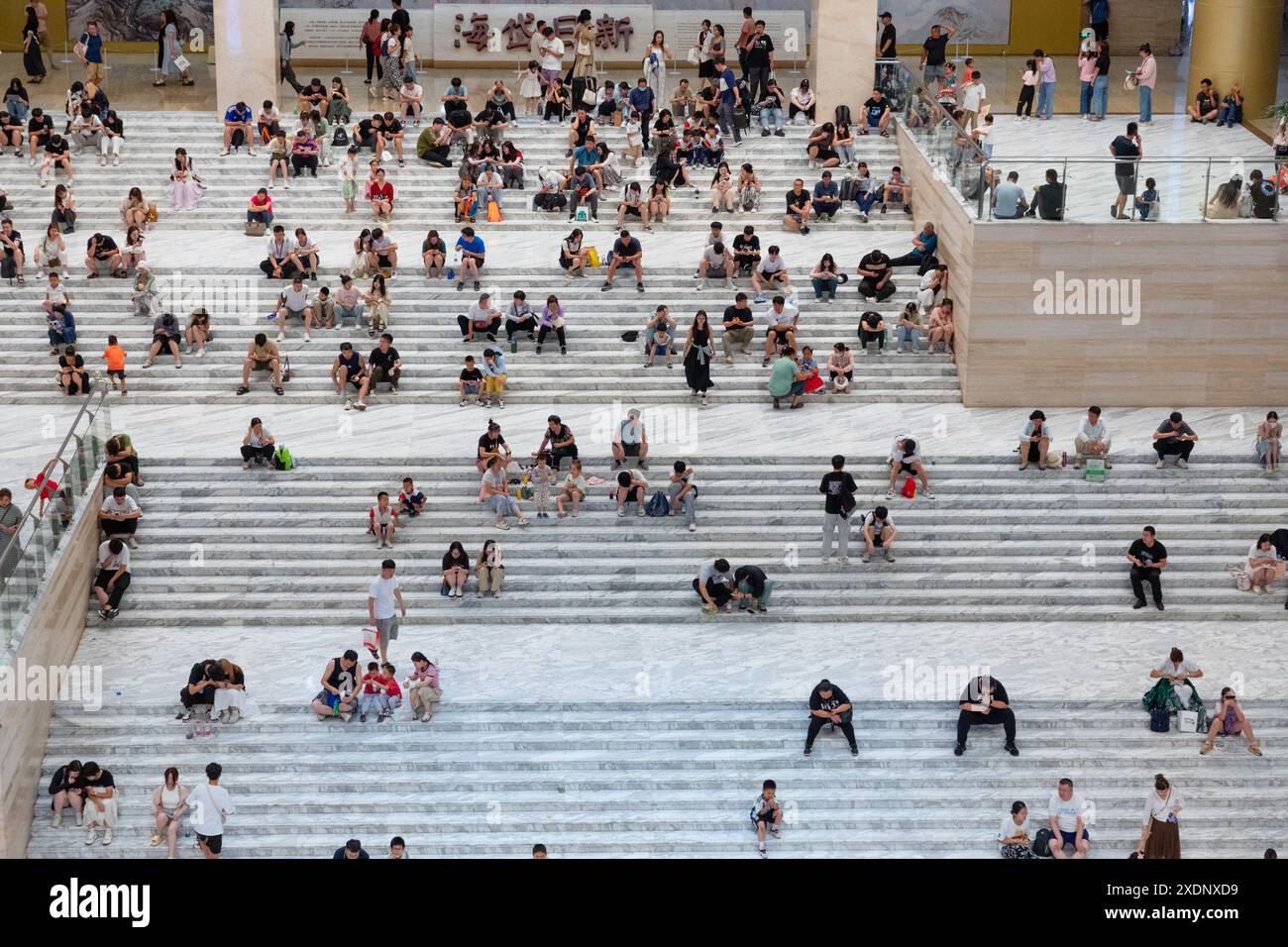 JINAN, CHINE - 23 JUIN 2024 - les gens sont assis sur les marches de la salle du musée du Shandong pour se rafraîchir dans la province du Shandong, province du Shandong en Chine orientale Banque D'Images