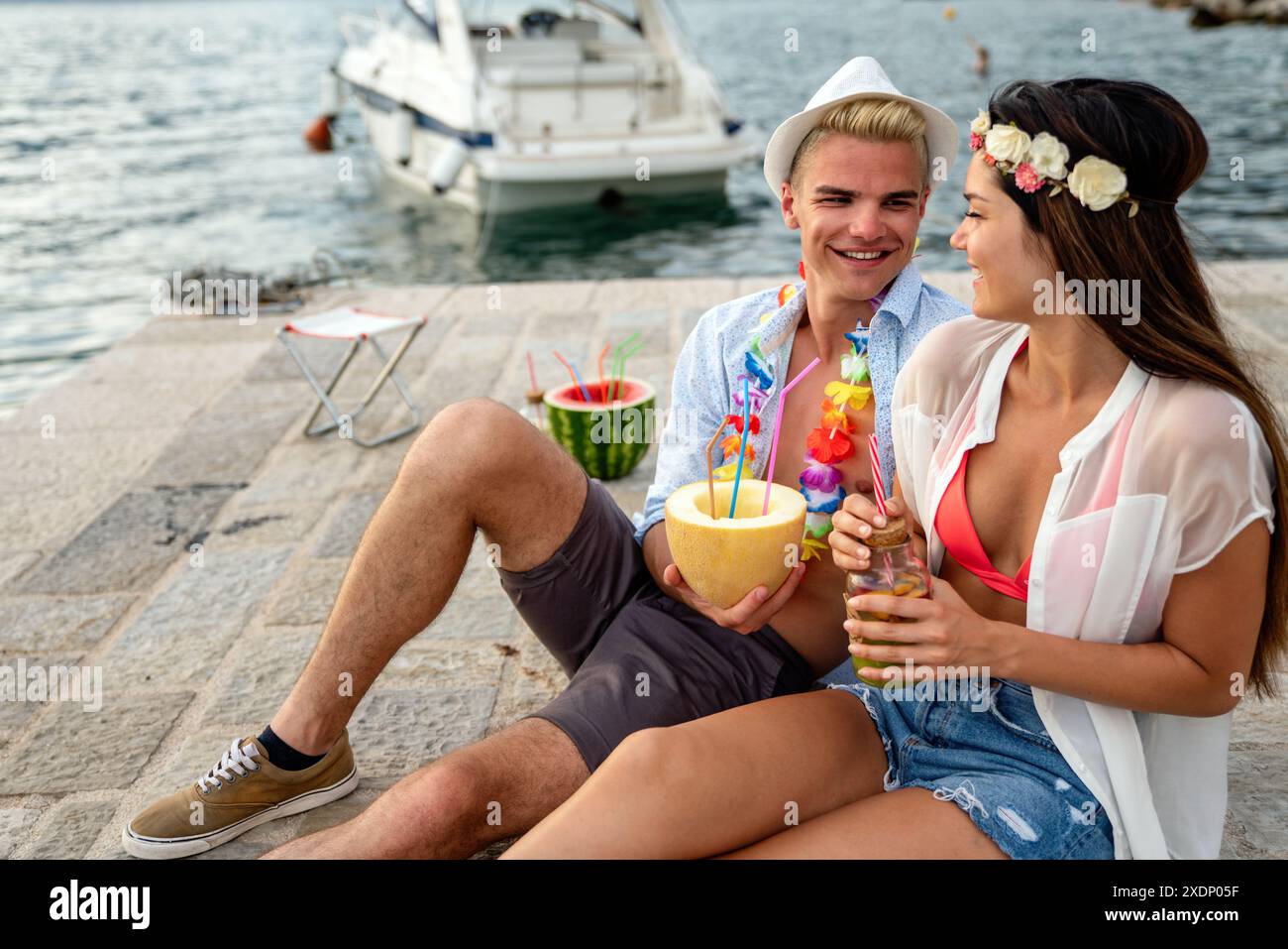 Heureux jeune couple multiethnique en amour sont sur une date, profitant de cocktails sur la plage Banque D'Images