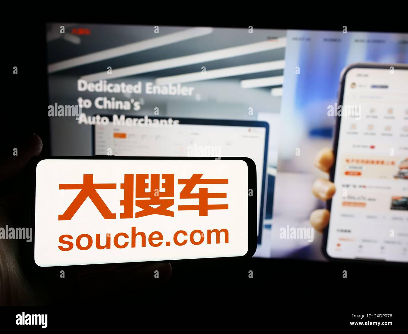 Personne tenant un smartphone avec le logo de la société chinoise de marché automobile soupe Holdings Ltd en face du site Web. Concentrez-vous sur l'affichage du téléphone. Banque D'Images