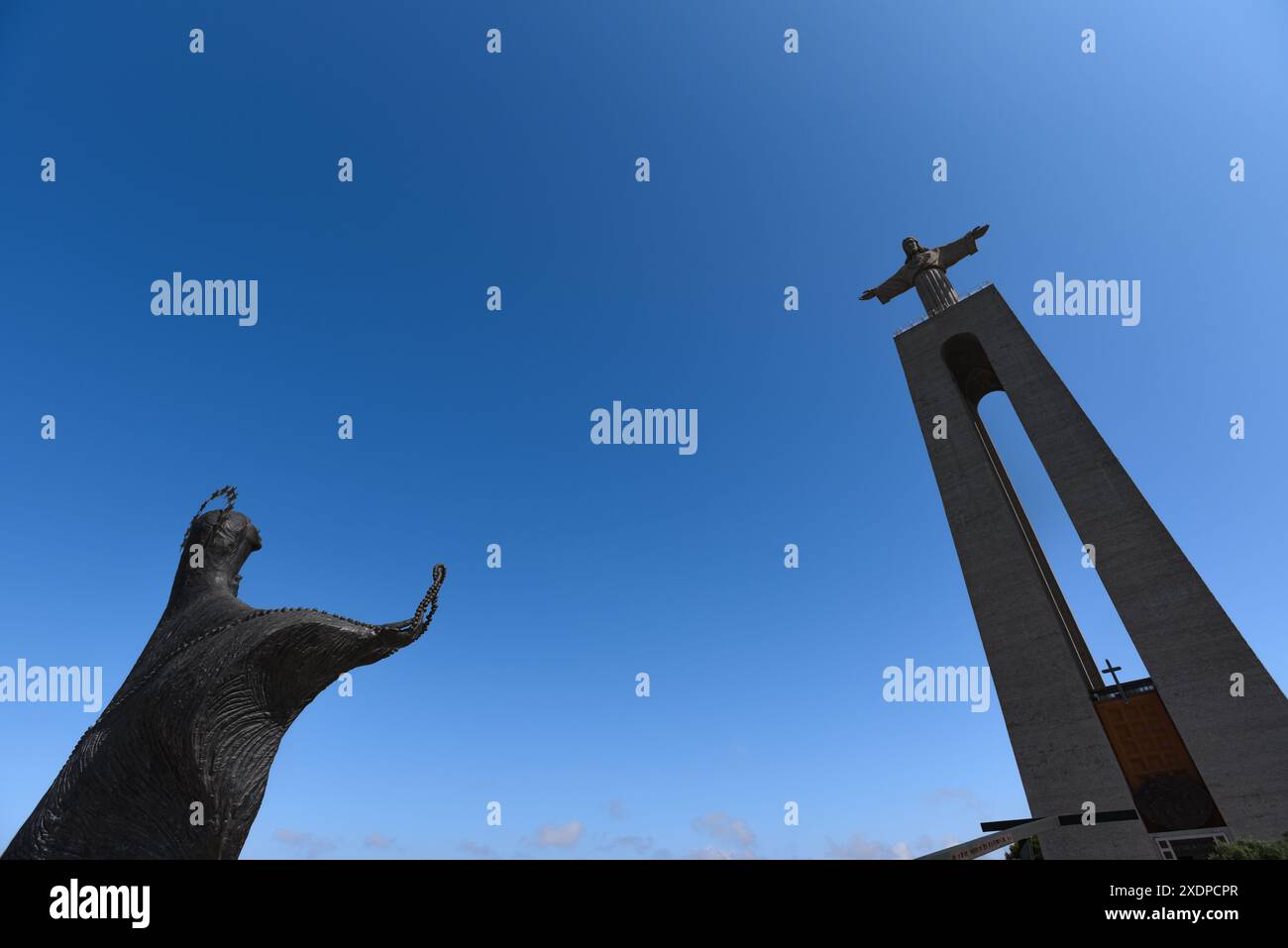 Vue en angle bas de Cristo Rei et des statues de la Vierge Marie au Sanctuaire d'Almada - Portugal Banque D'Images