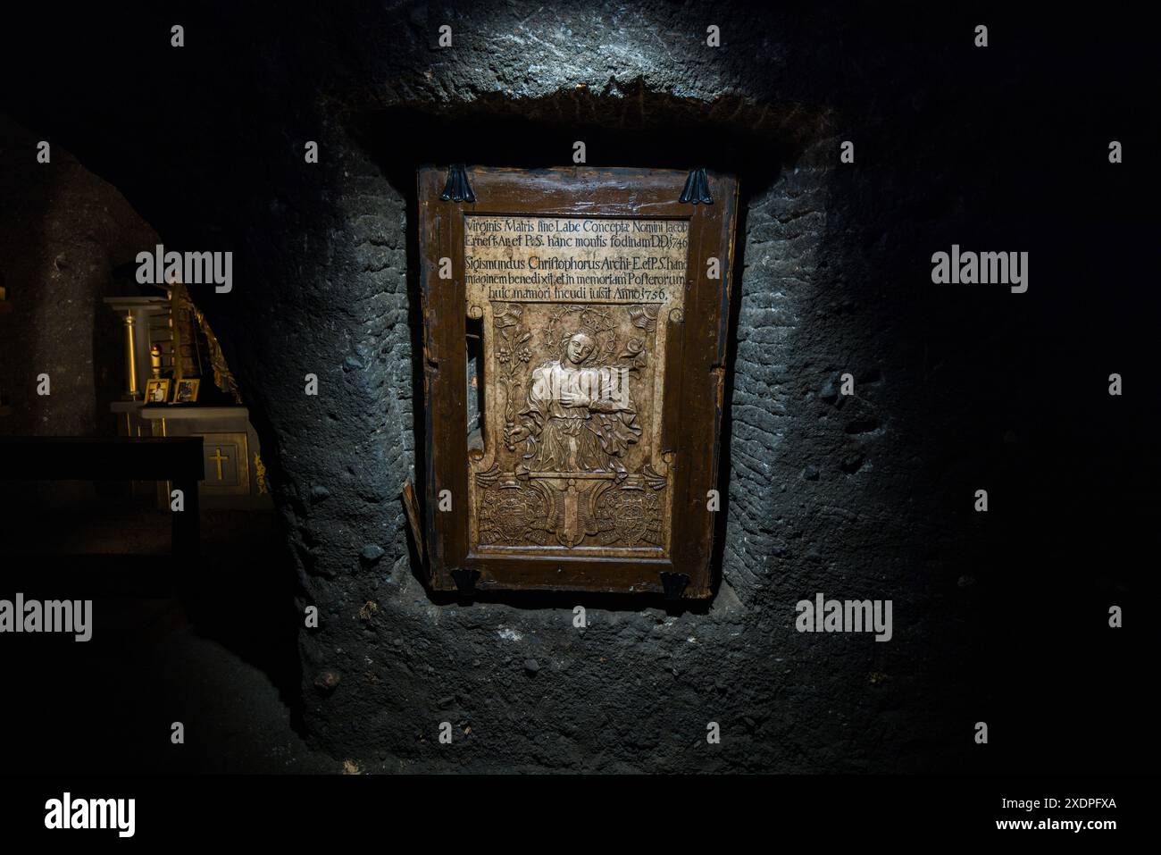 Un panneau de relief en bois sculpté représentant un évêque et portant une inscription latine datée de 1736 est suspendu dans une petite chapelle située dans un tunnel des Salzwelten Hallein près de Hallein, Salzbourg, Autriche. Les chapelles souterraines comme celle-ci reflètent la tradition religieuse séculaire des mineurs. La figure de l'évêque avec un bâton pastoral représente peut-être saint Rupert, le saint patron de l'exploitation du sel et de la ville de Salzbourg. Banque D'Images