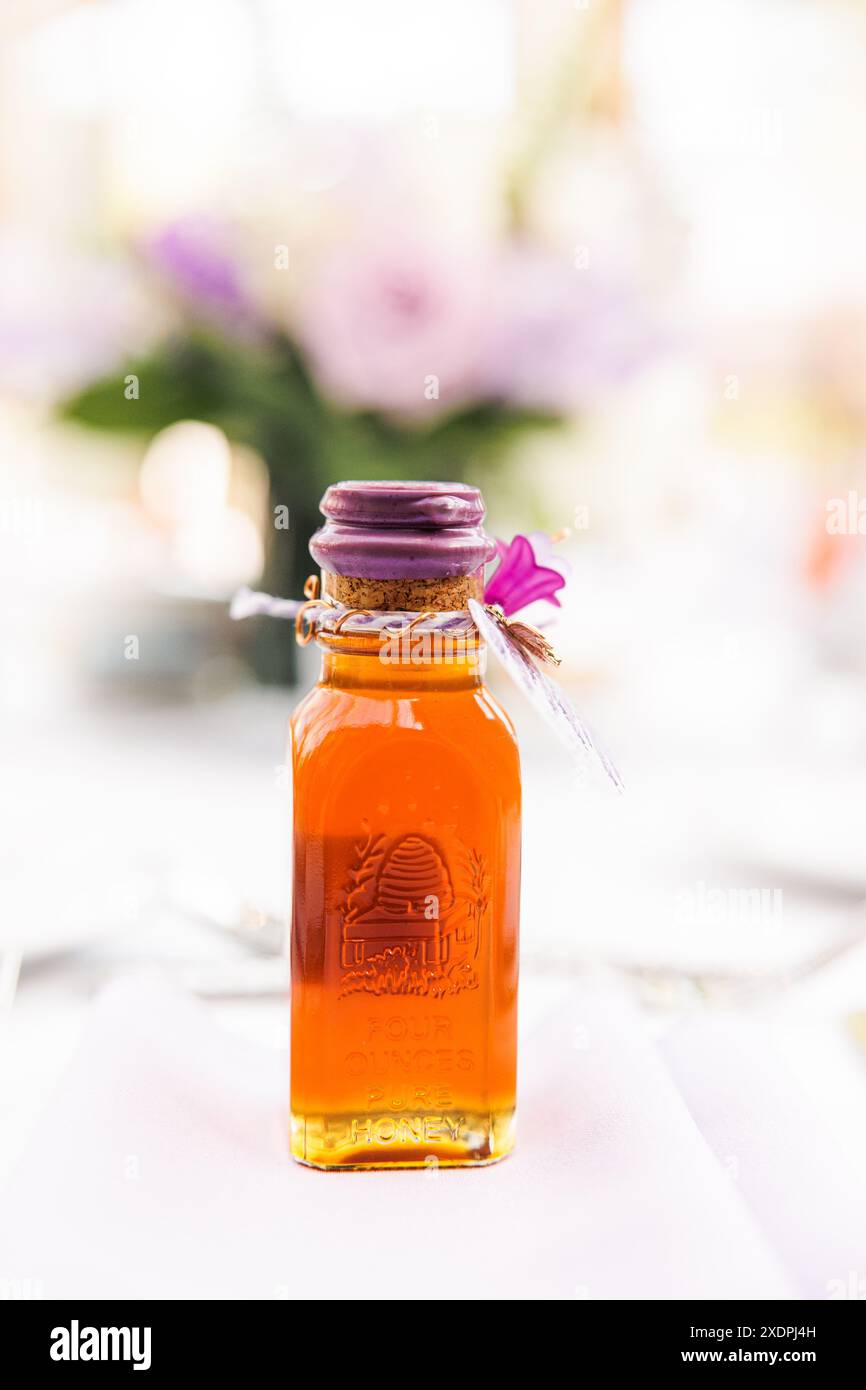 Gros plan d'une petite bouteille de miel avec un sceau de cire violet sur une table Banque D'Images
