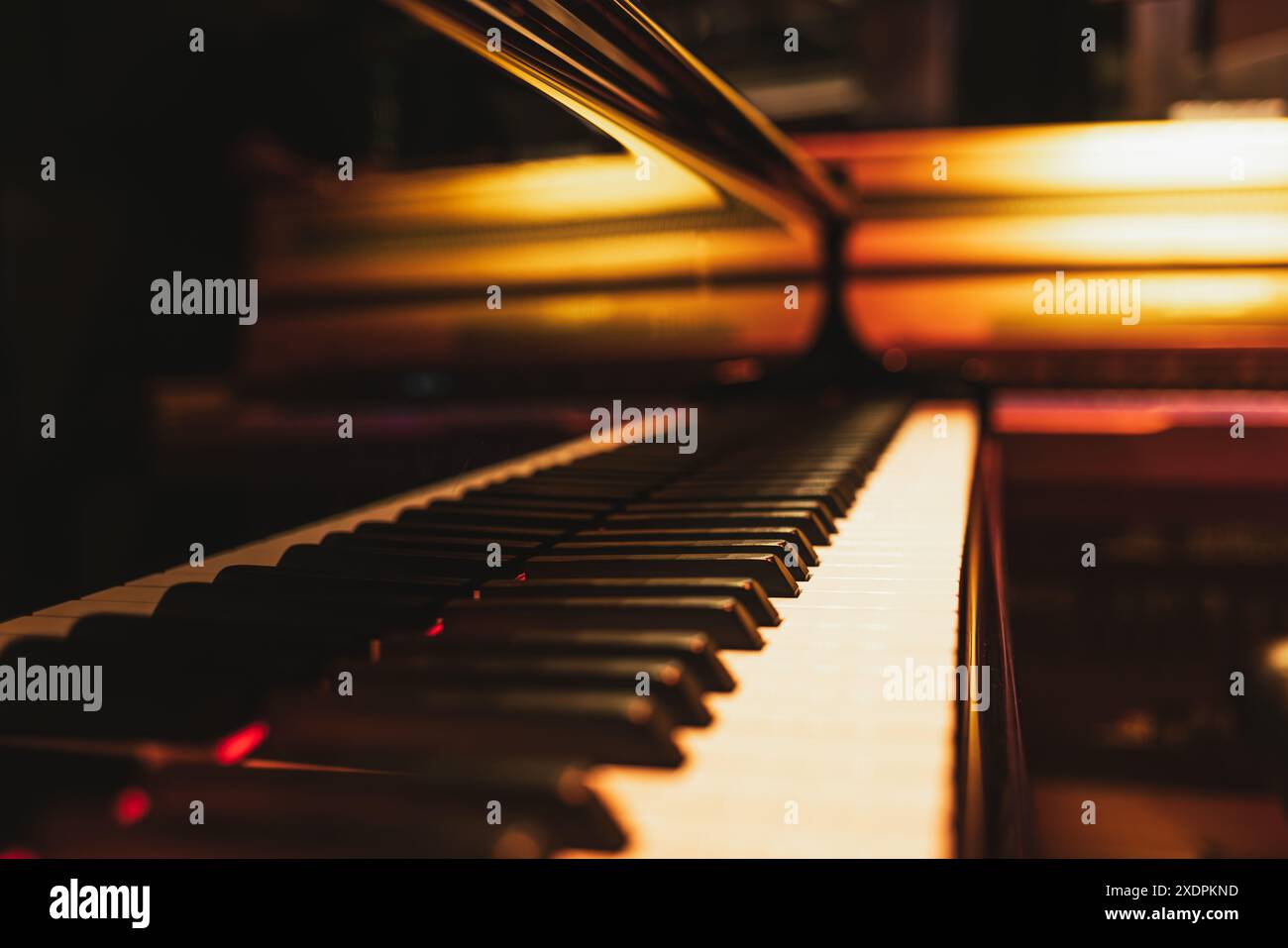 Gros plan des touches de piano avec un orchestre de fond chaud et flou Banque D'Images