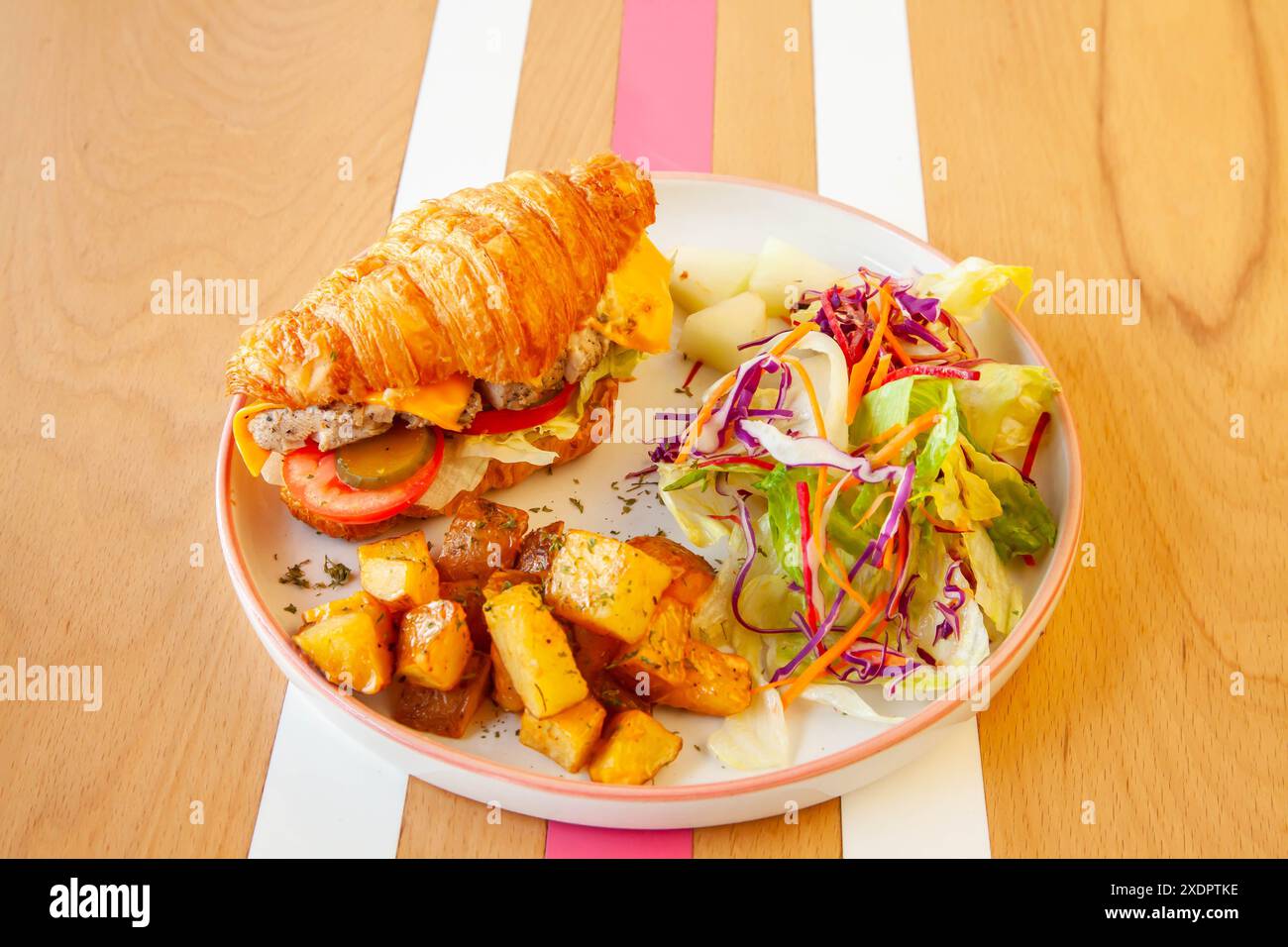 Sandwich croissant brioche au poulet servi dans une assiette dans un café-restaurant. Banque D'Images