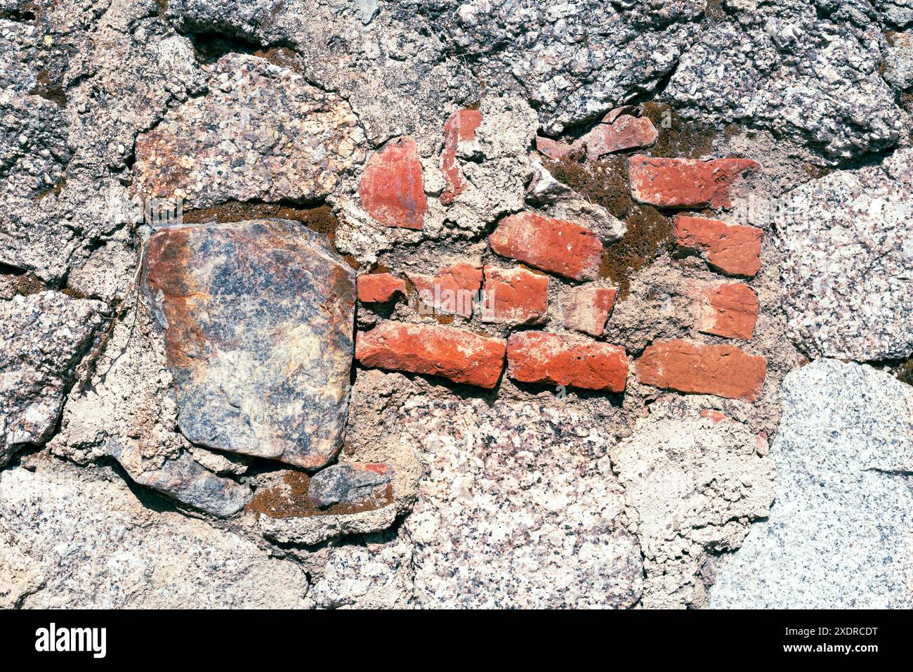 Texture de vieux mur de maison en pierres de granit et briques rouges. Banque D'Images