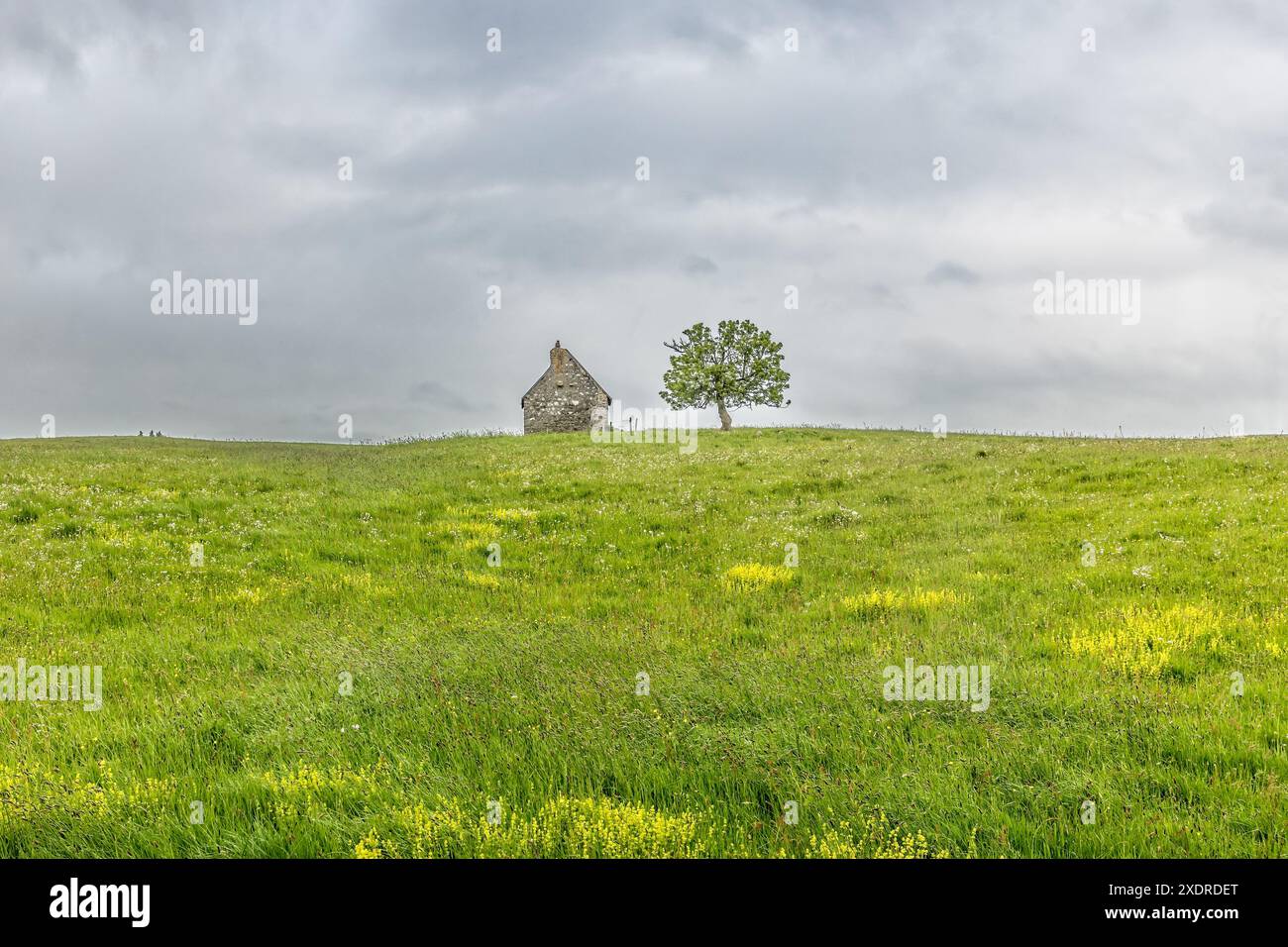 Ancienne maison en pierre abandonnée sur colline en Auvergne, ciel datk et mauvais temps Banque D'Images