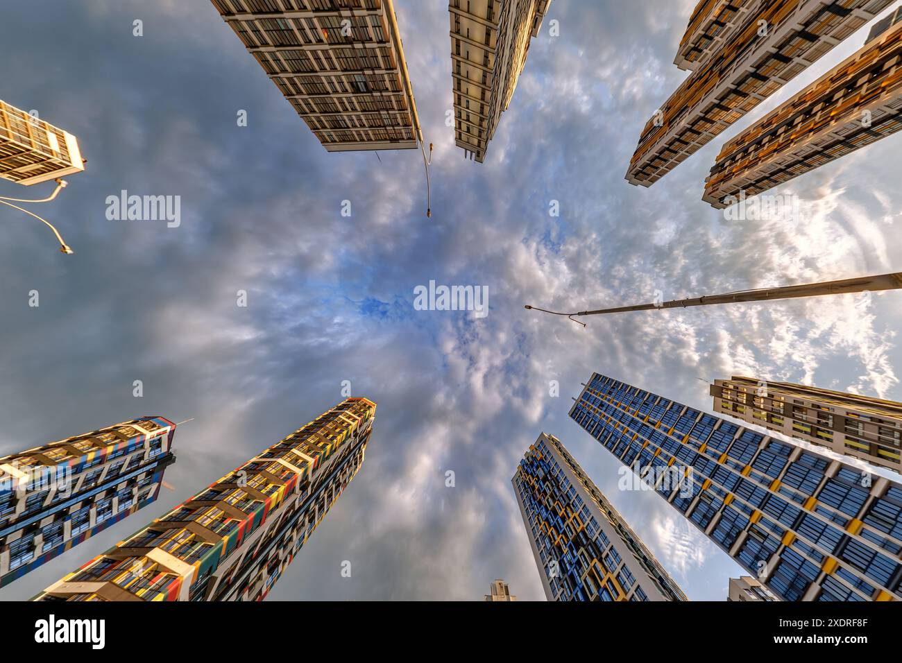 vue d'en bas dans le ciel orageux avec des nuages sombres de grand complexe résidentiel de gratte-ciel moderne Banque D'Images