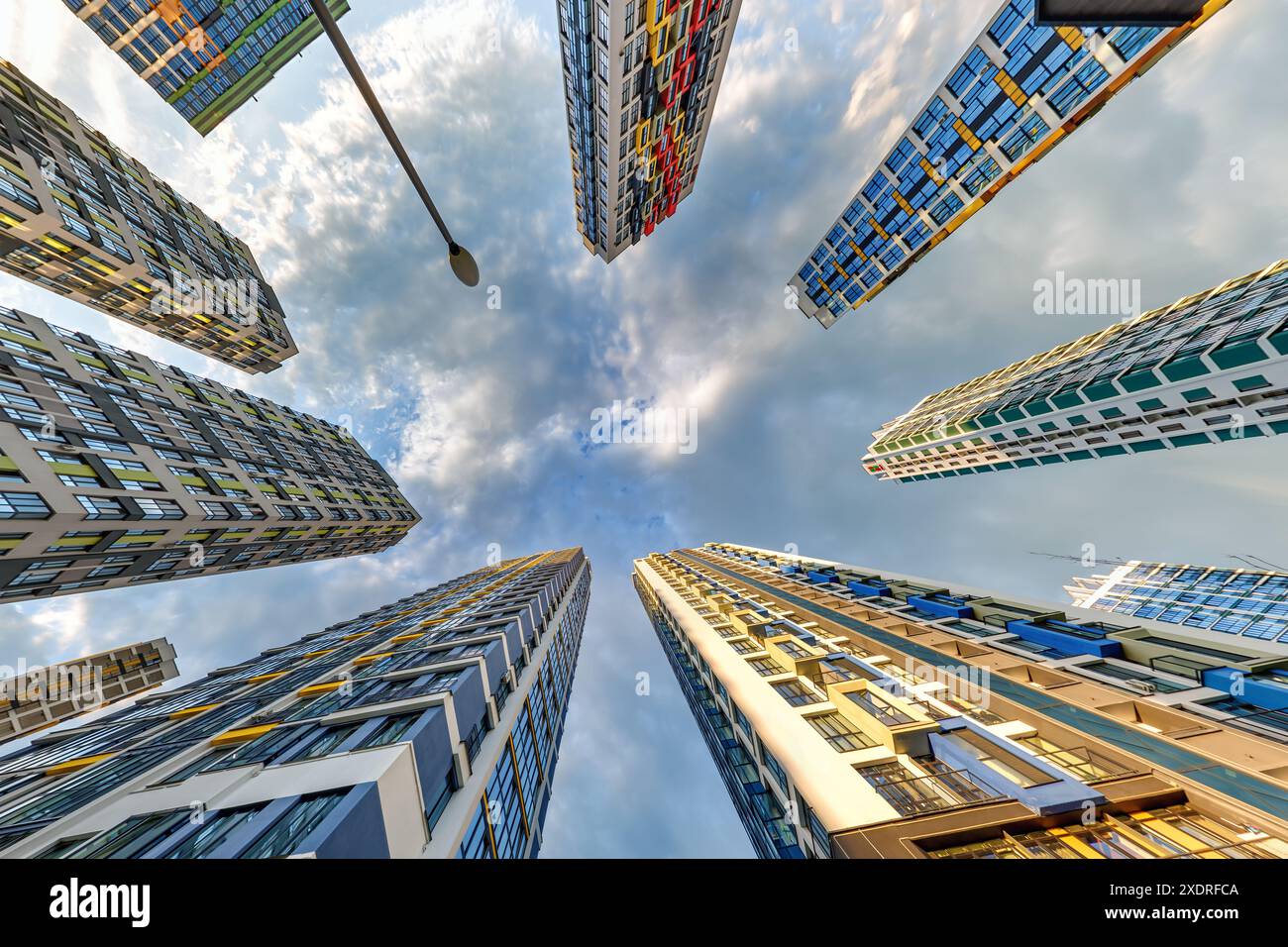 vue d'en bas dans le ciel orageux avec des nuages sombres de grand complexe résidentiel de gratte-ciel moderne Banque D'Images