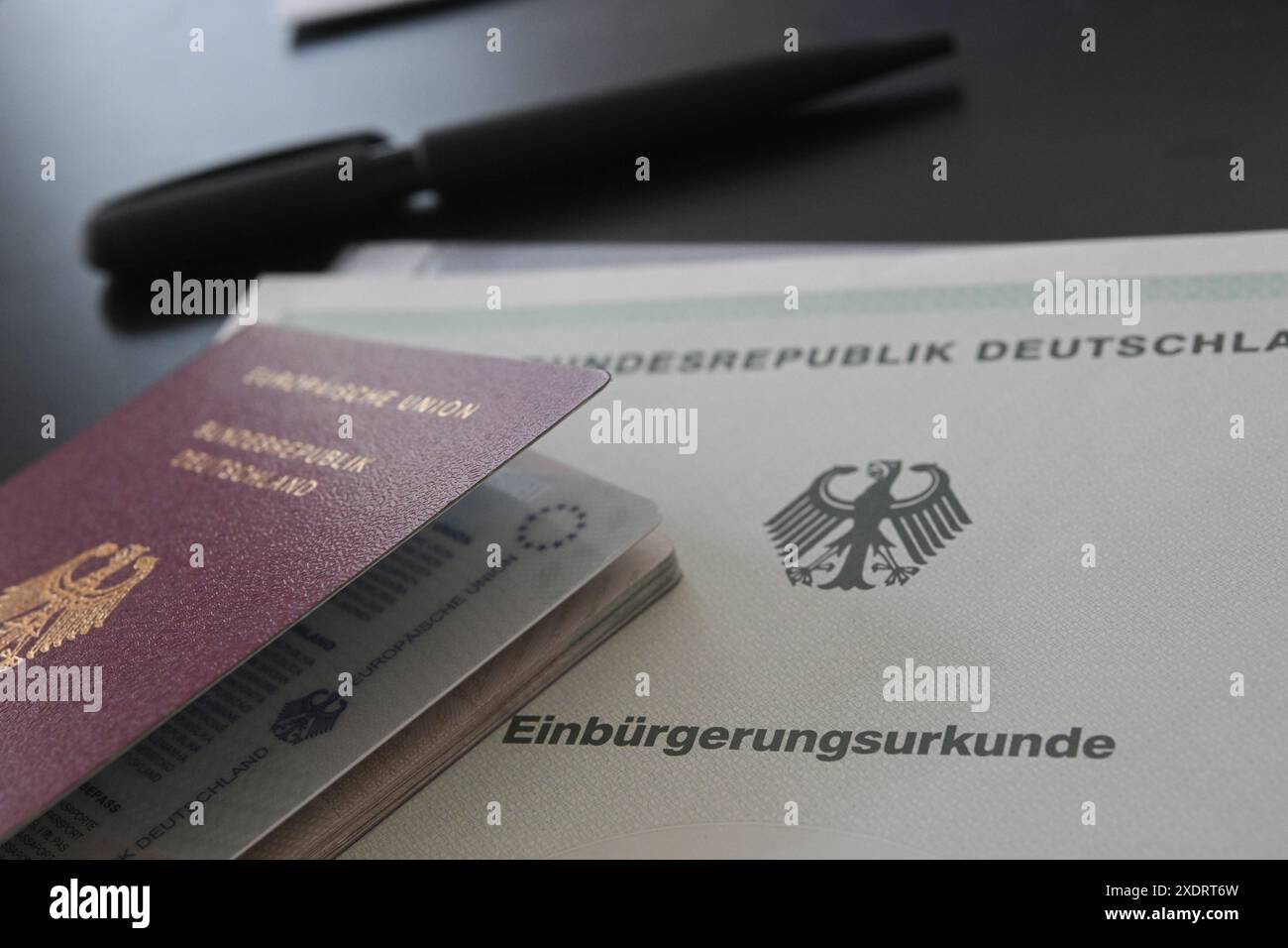 Stuttgart, Allemagne. 24 juin 2024. Un passeport allemand et un certificat de naturalisation reposent sur une table. Crédit : Marijan Murat/dpa/Alamy Live News Banque D'Images