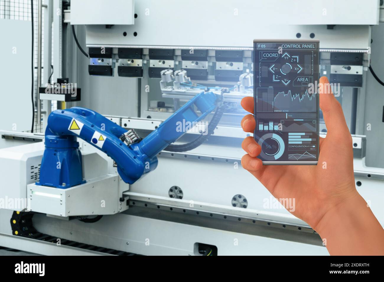 Engineer utilise un smartphone transparent futuriste pour contrôler les robots dans une usine intelligente. Smart Industry 4,0 concept.. Banque D'Images