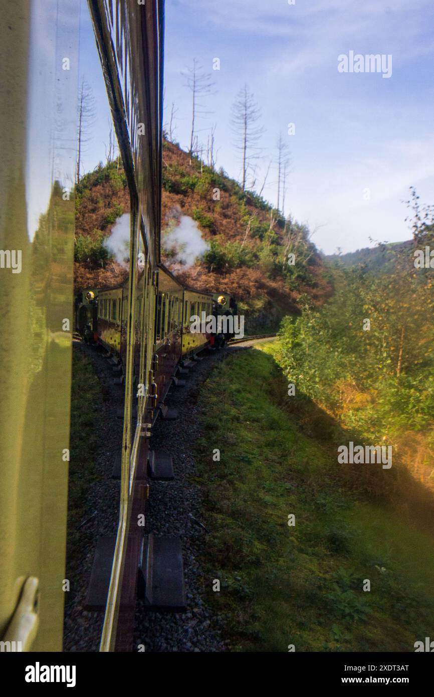 Train à vapeur vintage passant autour d'un coin et se reflétant en lui-même dans les montagnes cambriennes du pays de Galles Banque D'Images