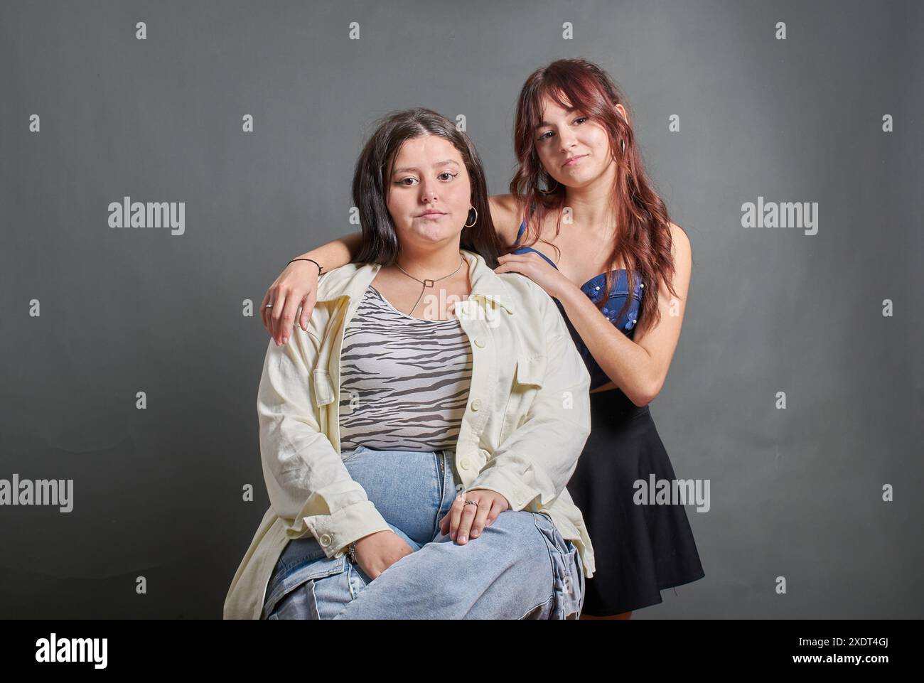 Deux femmes posent pour une photo, l'une d'elles porte une chemise blanche avec un imprimé zèbre. L'une des filles est en surpoids et l'autre est très peau Banque D'Images
