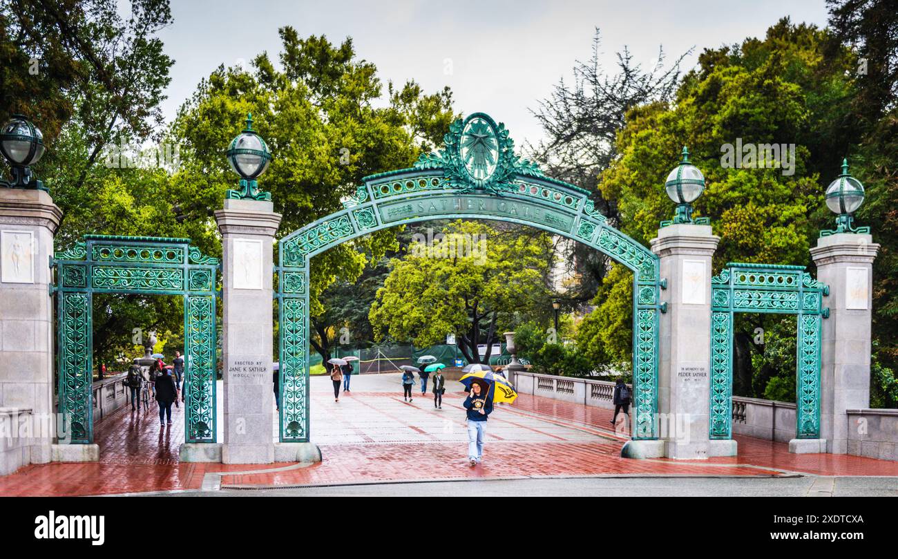 Berkeley, Californie États-Unis - 24 mars 2017 : guide étudiant de l'université de Berkeley passant sous l'entrée de Sather Gate un jour de pluie. Banque D'Images