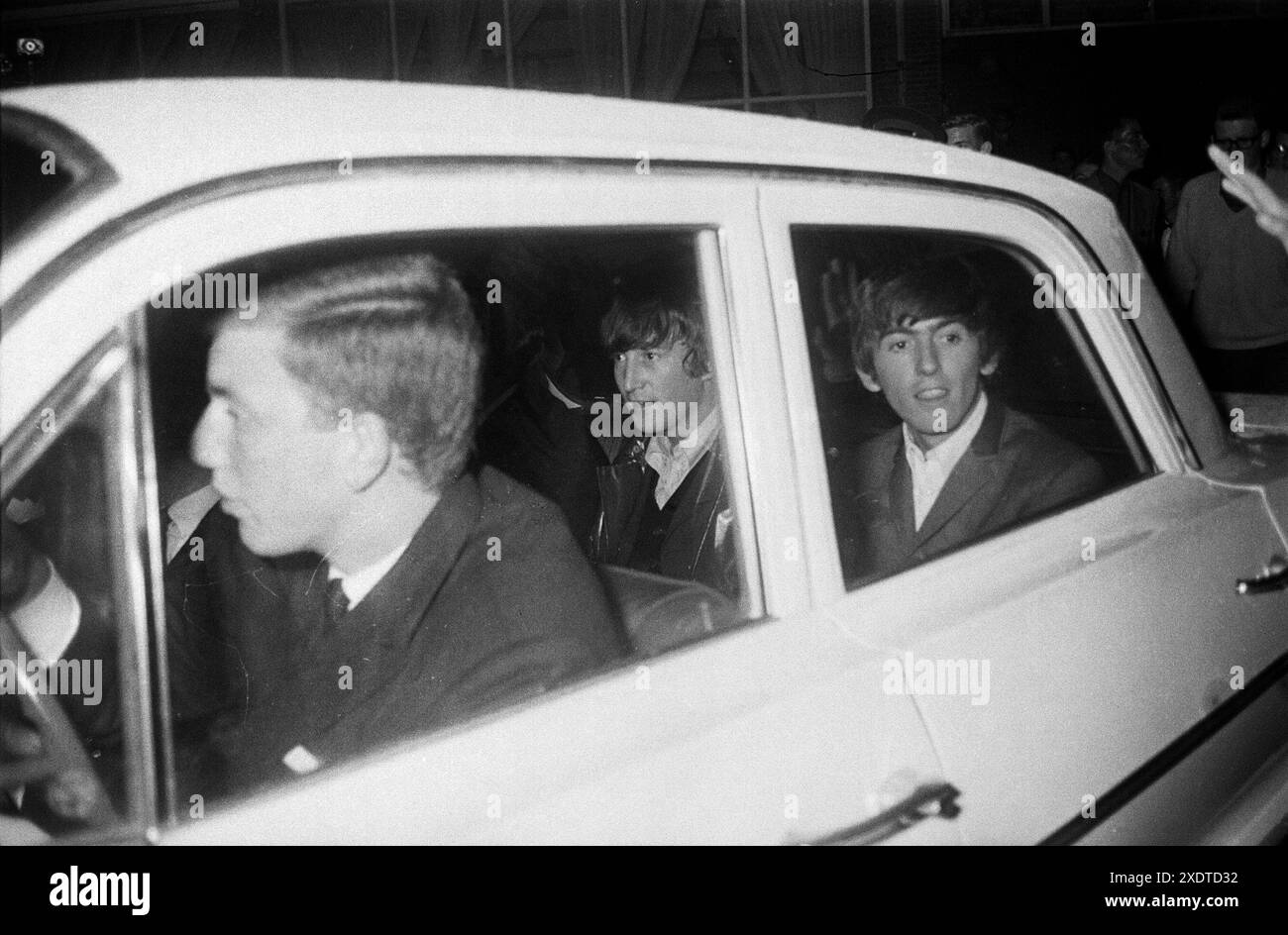 Les Beatles dans une voiture (John Lennon et George Harrison visibles) quittant un studio de télévision. Treslong, pays-Bas, Hollande. Juin 1964 Banque D'Images