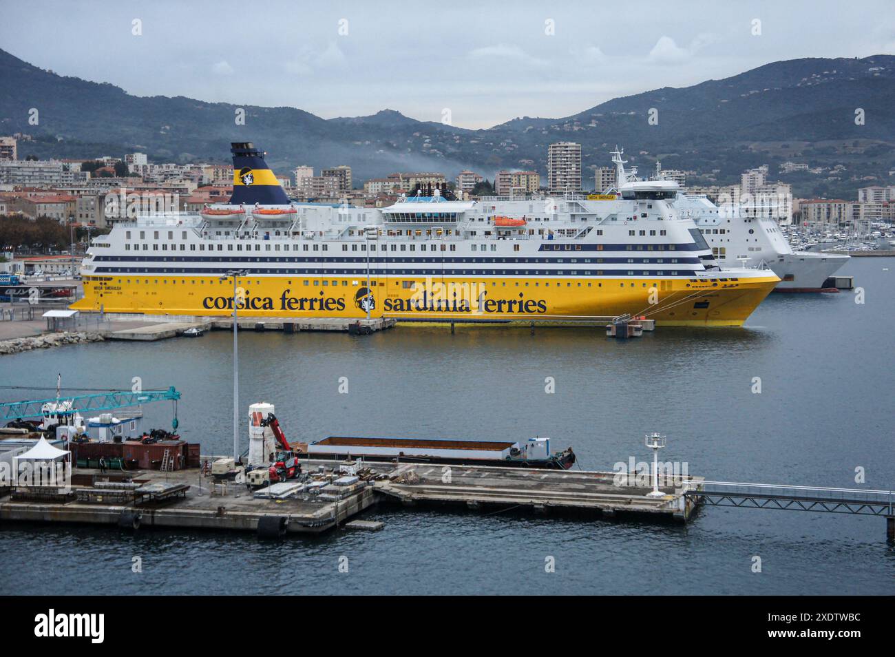 Ajaccio, Corse, France. 23 juin 2024 : Corsica Ferries transporte dans le port avec le logo de la compagnie peint sur la coque jaune et l'entonnoir. Le Conseil d'État, juridiction administrative suprême, a rendu un verdict rejetant définitivement la nature juridique du pilotage maritime comme étant "une redevance pour services rendus", suite à une demande de Corsica Ferries visant à annuler un décret relatif aux coûts d'une station pilote en Corse. La compensation des pilotes a toujours été controversée dans de nombreux ports du monde entier. Crédit : Kevin Izorce/Alamy Live News Banque D'Images