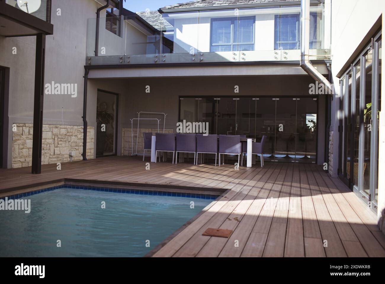 Maison moderne avec terrasse en bois et piscine dans un patio arrière spacieux, espace copie Banque D'Images