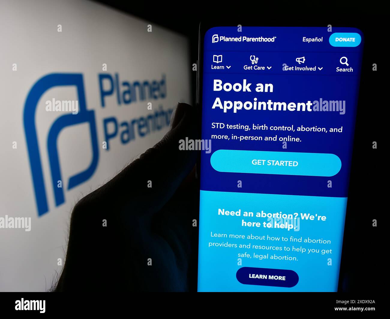 Personne tenant le téléphone portable avec la page Web de Planned Parenthood Federation of America Inc (PPFA) devant le logo. Concentrez-vous sur le centre de l'écran du téléphone. Banque D'Images