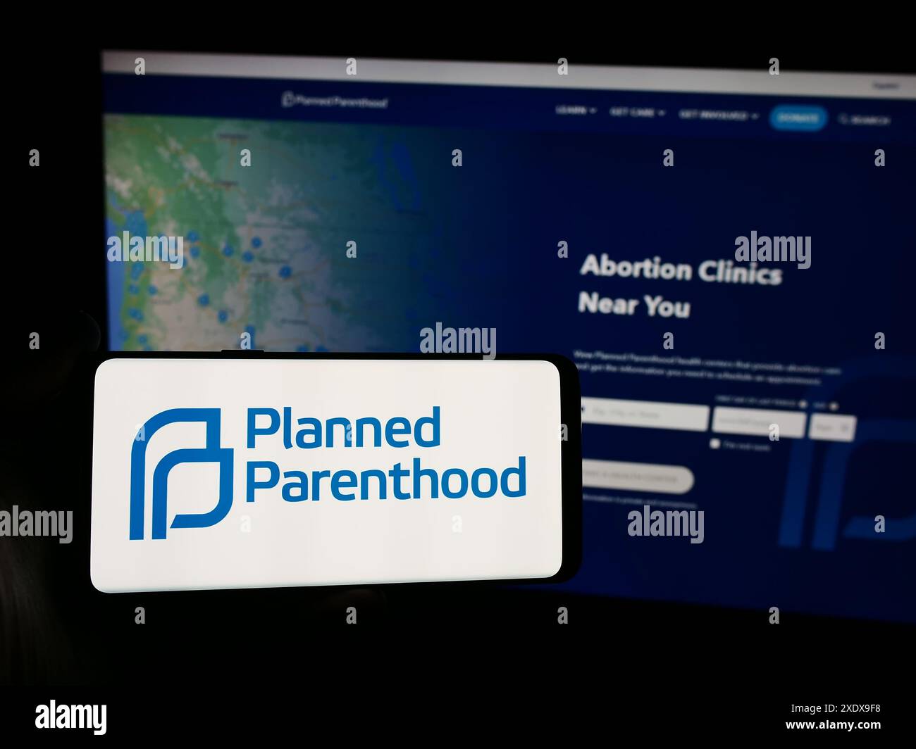 Personne tenant un smartphone avec le logo de Planned Parenthood Federation of America Inc (PPFA) devant le site Web. Concentrez-vous sur l'affichage du téléphone. Banque D'Images