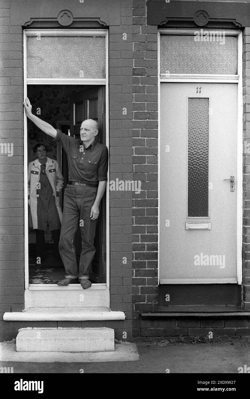 Charlie Hayward, mineur de charbon à la retraite, et sa femme Lilian à la porte d'entrée. Il a passé 49 ans à la mine South Kirkby. Il est descendu de la fosse quand il avait 14 ans et a pris sa retraite 49 ans plus tard quand il avait 63 ans. Il a un emphysème respiratoire à l'extérieur de la porte d'entrée de sa maison NUM. South Kirkby, Yorkshire Angleterre 1979. ANNÉES 1970 ROYAUME-UNI HOMER SYKES Banque D'Images