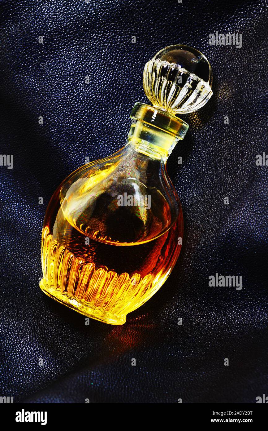 Bouteille vintage de parfum sur cuir Banque D'Images