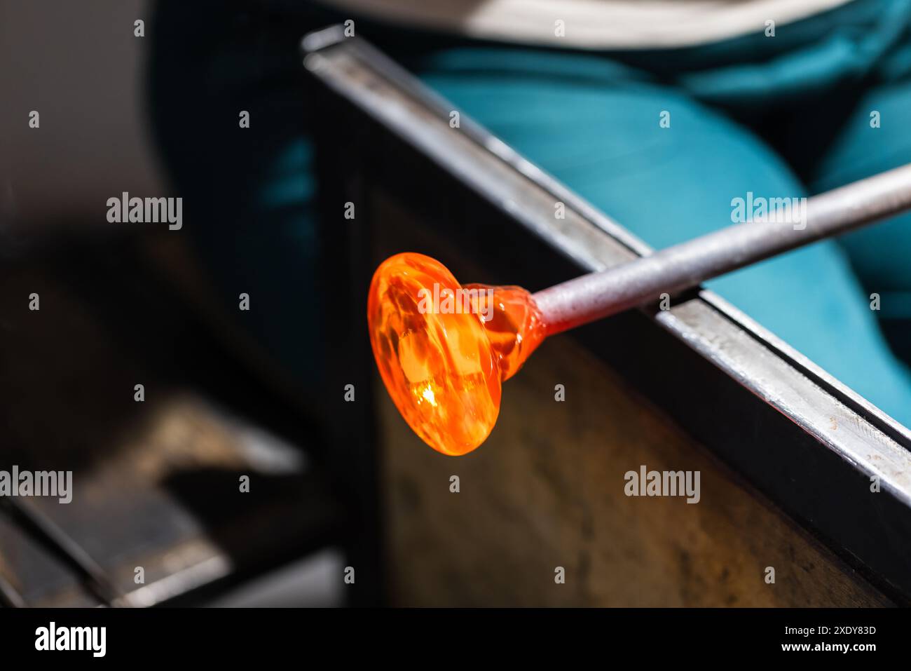 L'ébauche de verre fondu tourne sur le tuyau de soufflage au studio de soufflage de verre Banque D'Images