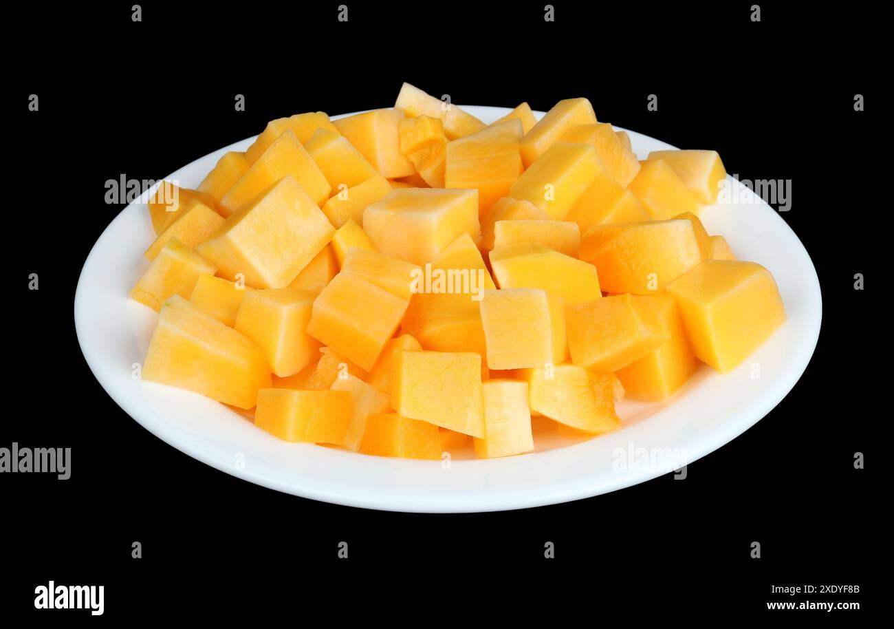 Tranches de citrouille orange douce sur une plaque blanche isolée noire Banque D'Images Tranches de citrouille orange douce sur une plaque blanche isolée noire Banque D'Images