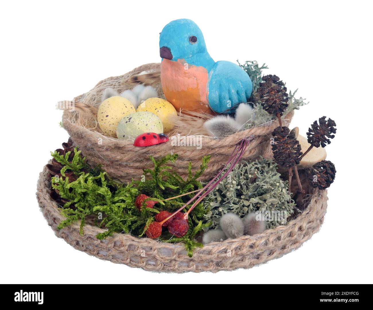 Nid de Pâques fait à la main à partir de corde et de mousse avec drôle d'oiseau d'argile bleue et des œufs isolés Banque D'Images