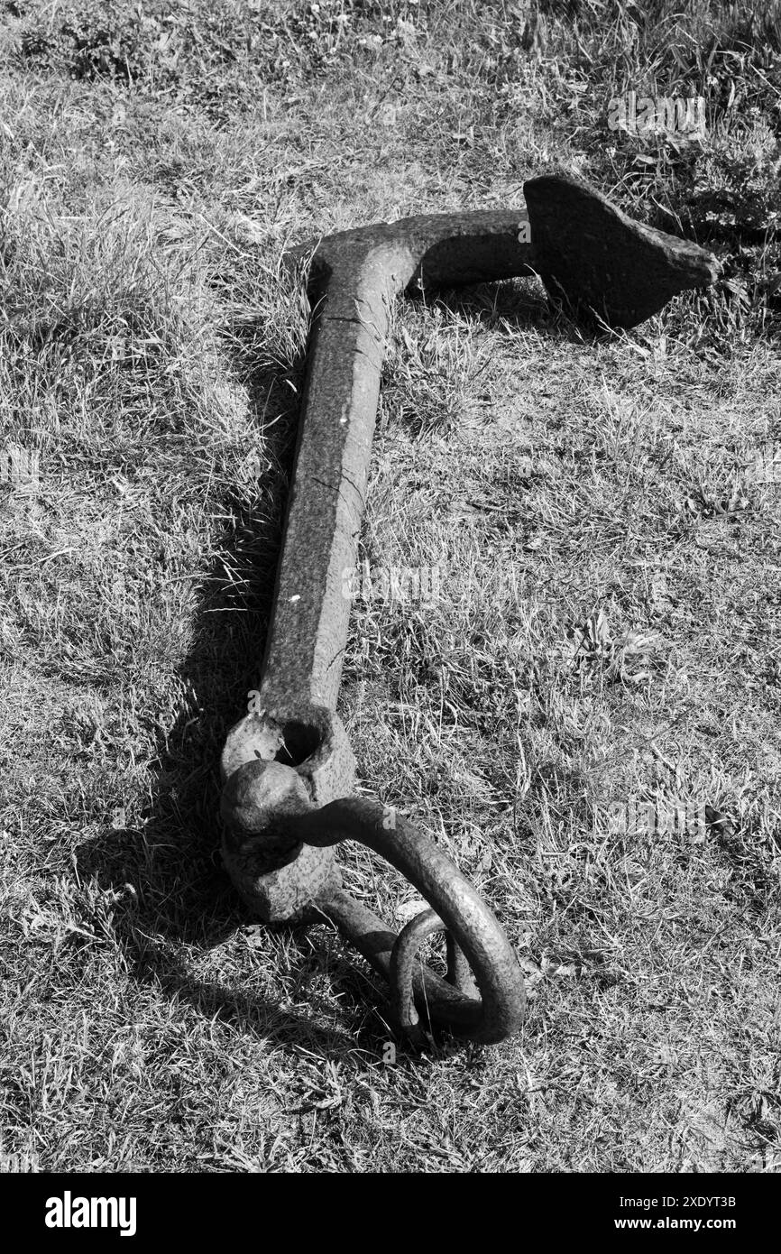 Image en noir et blanc de l'ancre brisée couchée dans l'herbe sur la baie de l'île Sainte de Lindisfarne en reconnaissance de la flotte historique de bateaux de hareng Banque D'Images