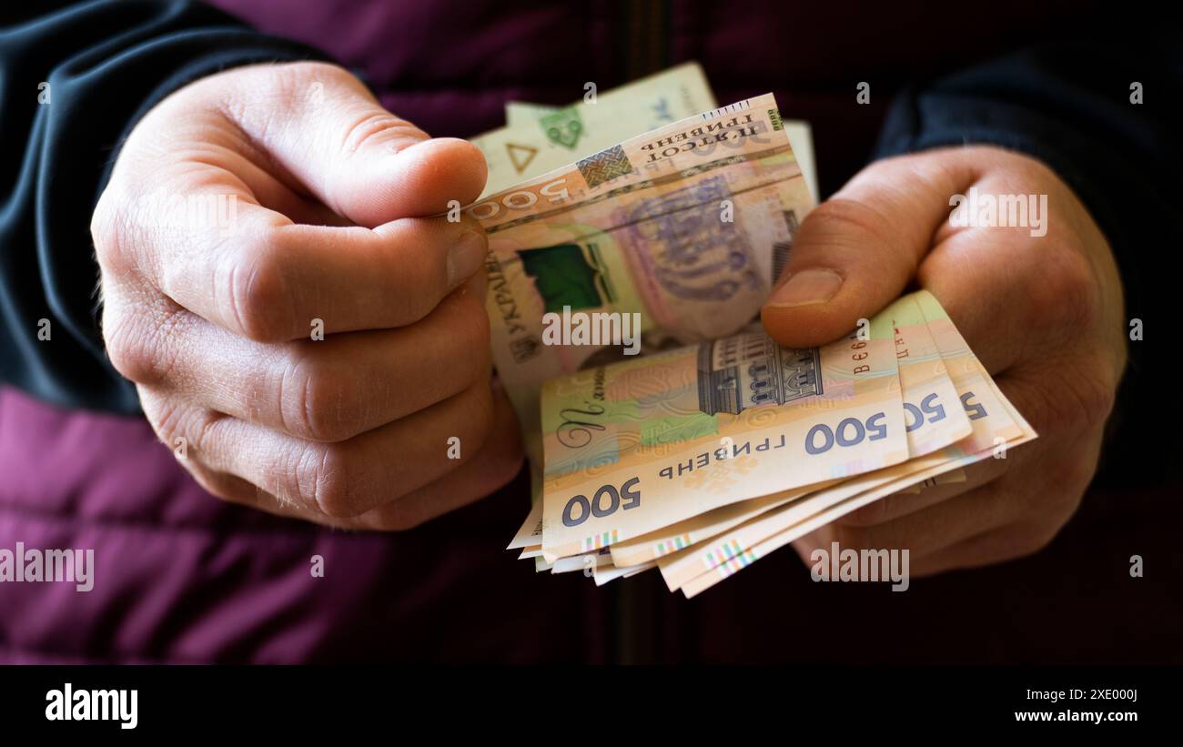 Les hommes blancs comptent Ukrainian hryvnia cinq cents billets dans ses mains Banque D'Images