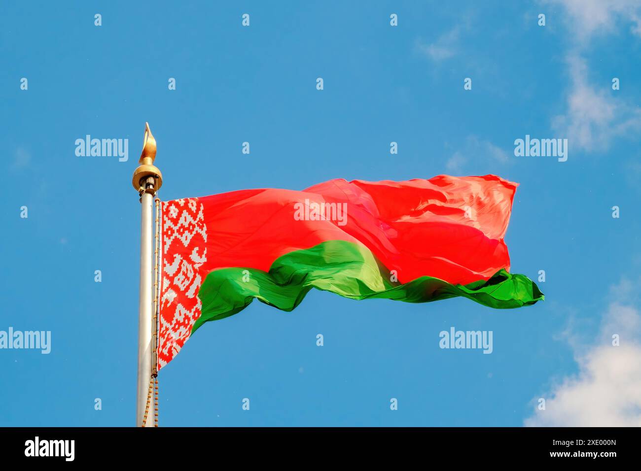 Drapeau de la République de Biélorussie vole dans le vent contre le ciel bleu. Gros plan. Banque D'Images