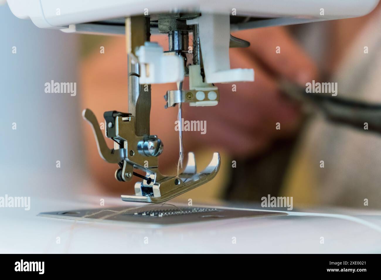 Gros plan sur les pièces de la machine à coudre - pied et aiguille. Mise au point sélective Banque D'Images