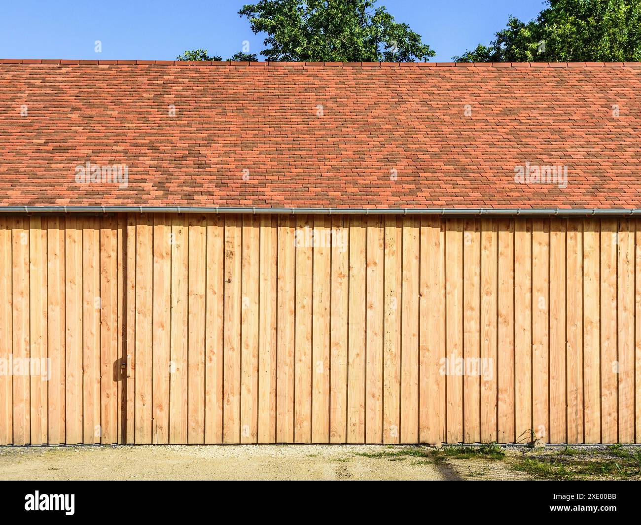 Nouveau bâtiment de stockage agricole revêtu de bois avec porte coulissante en bois - Boussay, Indre-et-Loire (37), France. Banque D'Images