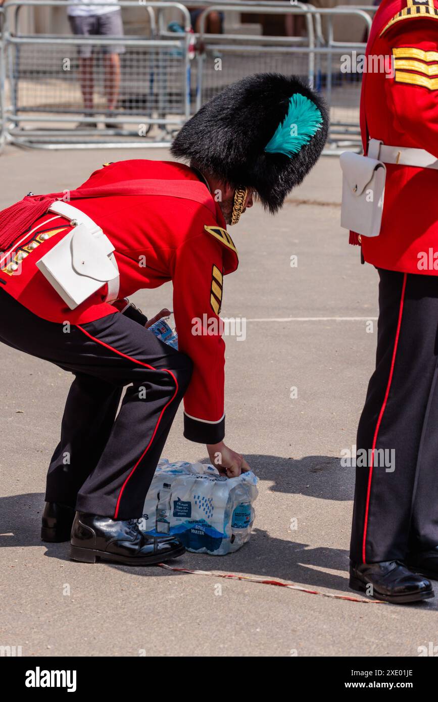 The Mall, Londres, Royaume-Uni. 25 juin 2024. Band of the Irish Guards reçoit des bouteilles d'eau alors qu'elles se tiennent le long du Mall dans une chaleur de 30 degrés, le jour le plus chaud de l'année jusqu'à présent, avant le cortège en calèche après un accueil formel sur Horse Guards Parade lors de la visite d'État du Japon au Royaume-Uni. Crédit : Amanda Rose/Alamy Live News Banque D'Images