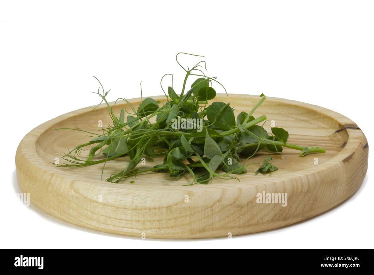 Germes de pois microverts dans un bol en bois. Pousses vertes de yak, jeunes plantes, pousses d'une plante savoureuse et utile. Photo macro de Banque D'Images