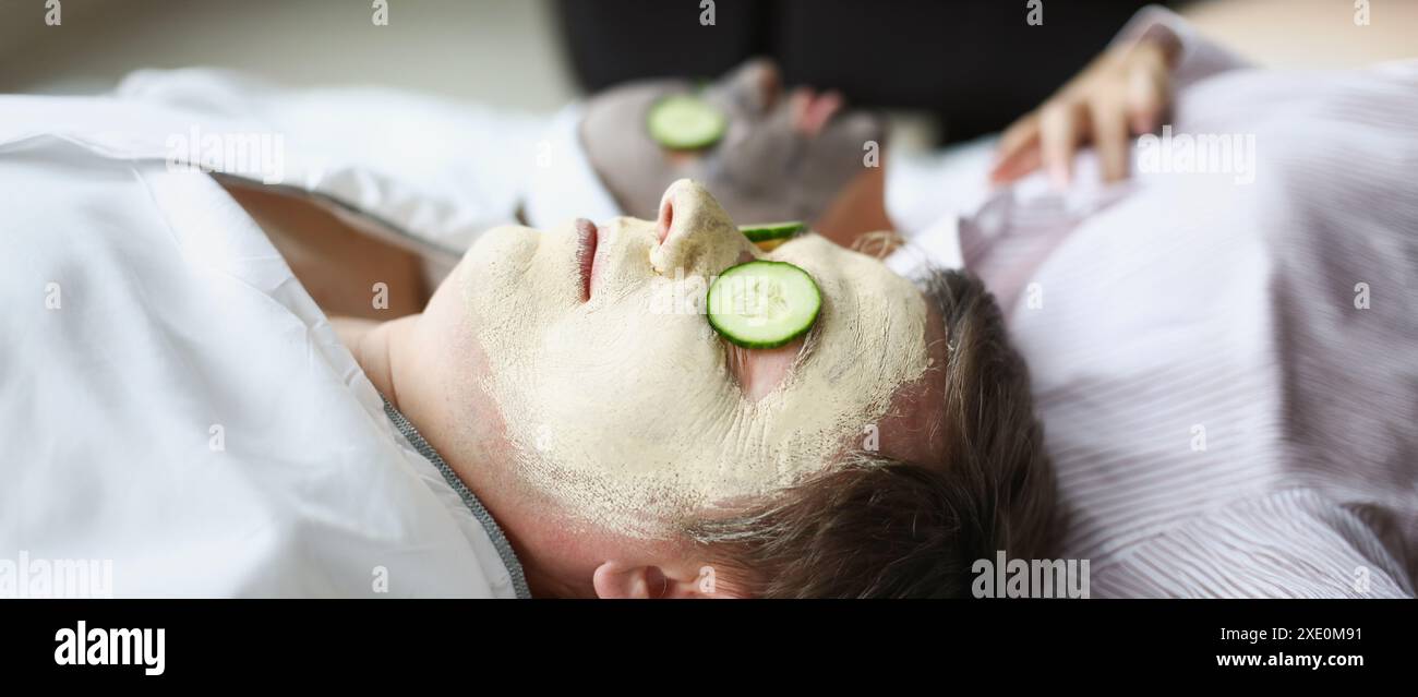 L'homme et la femme ont appliqué un masque rajeunissant en argile sur leurs visages. Masques faciaux tonifiants contre l'œdème et le concept de taches bleues Banque D'Images