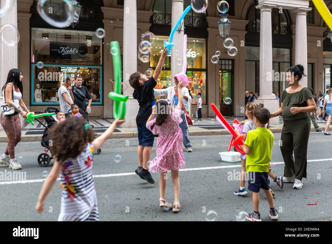 Turin, Italie - 22 juin 2024 : les enfants s'amusent à éclater des ballons de savon dans la rue à Turin, Italie. Banque D'Images