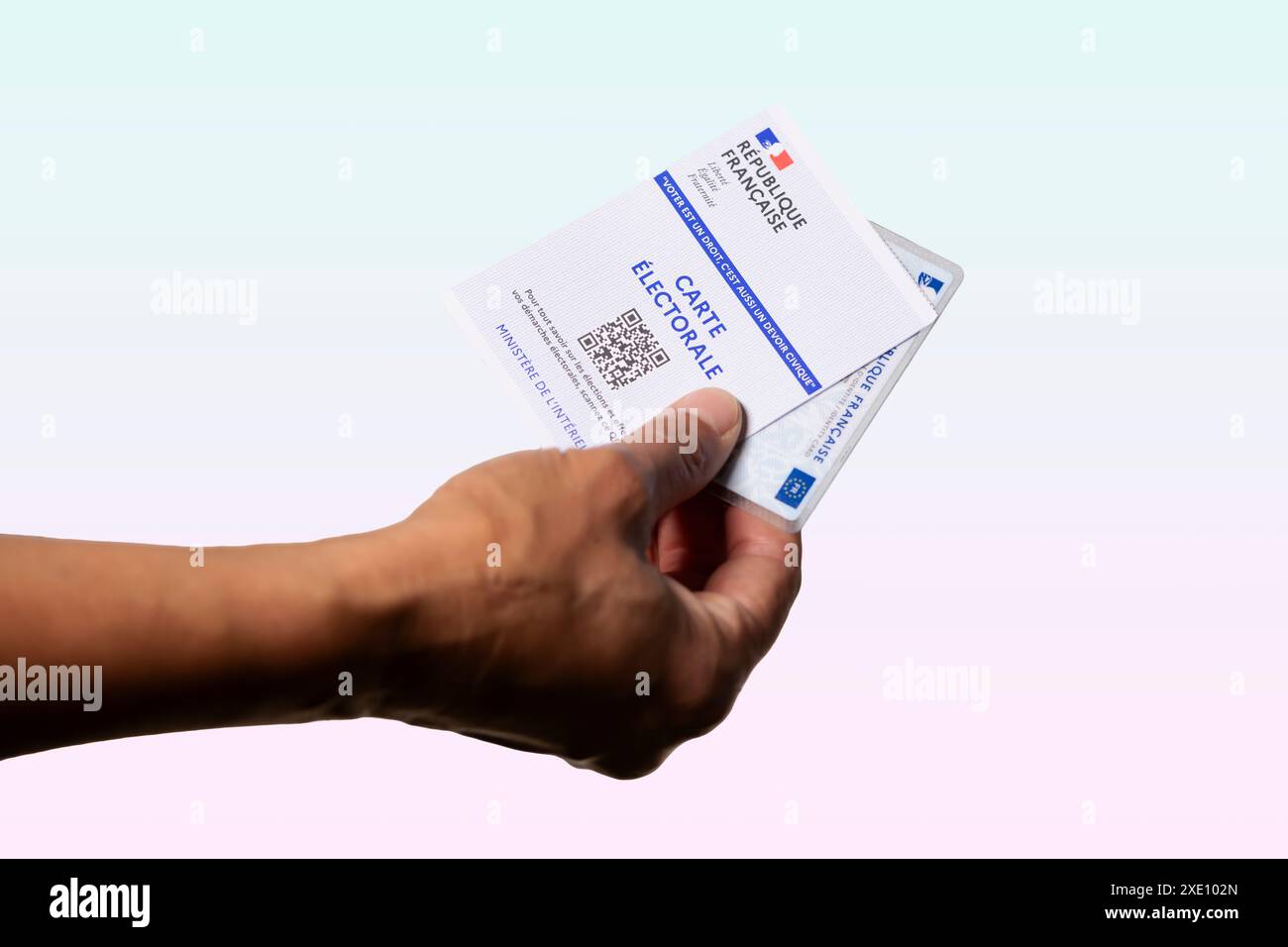 Femme titulaire d'une carte électorale et d'identité française sur fond de couleurs bleu clair et rouge, élections en France Banque D'Images
