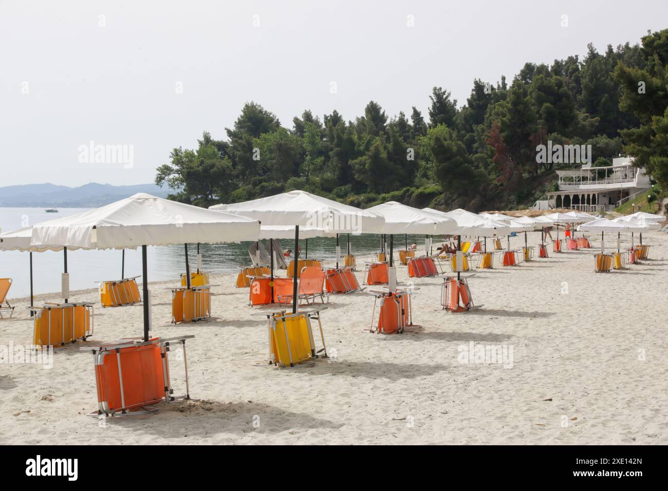 Parasols blancs avec des chaises de plage jaunes et orange sur une belle plage de sable, pas de gens Banque D'Images